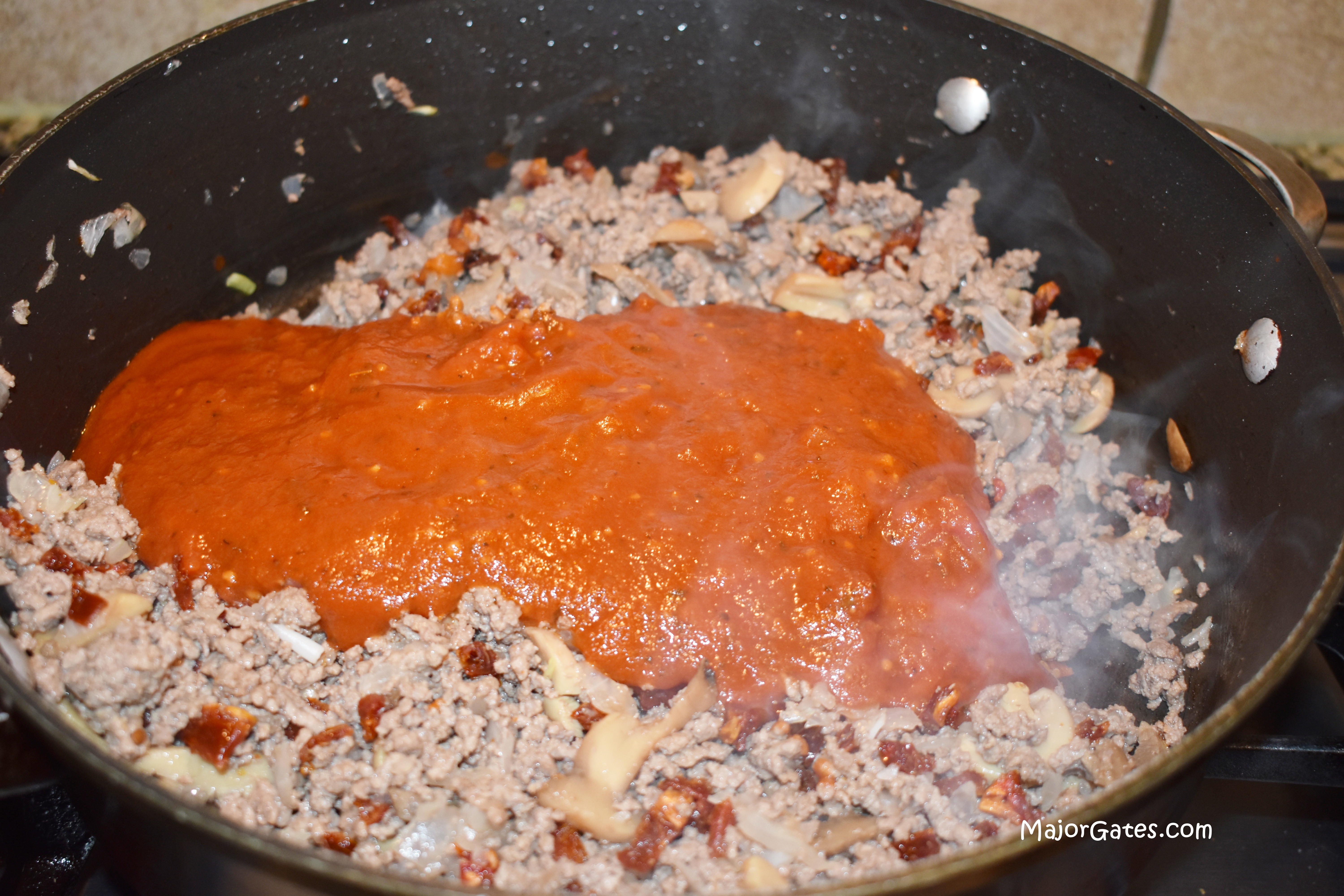Adding the pasta sauce to the meat mixture